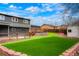 A turfed backyard features an elevated wooden deck with fencing and steps to a shed at 129 Gordon Pl, Castle Rock, CO 80104