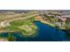 Aerial view of a golf course and pond surrounded by residential homes, offering both recreational opportunities and serene views at 15501 Fairway Dr, Commerce City, CO 80022