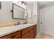 Bathroom with double sinks, stone backsplash, and black hardware at 15501 Fairway Dr, Commerce City, CO 80022