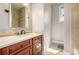 Bright bathroom featuring a stone countertop vanity and a tiled shower over tub at 15501 Fairway Dr, Commerce City, CO 80022