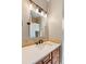 Well-lit bathroom vanity with stone countertop, decorative backsplash and dark wood cabinets at 15501 Fairway Dr, Commerce City, CO 80022