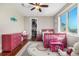 Bright bedroom with hardwood floors, ceiling fan, a large window and an adorable pink decor at 15501 Fairway Dr, Commerce City, CO 80022