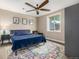 Bedroom with modern decor featuring a plush blue bed, dark wood accents, and a colorful rug at 15501 Fairway Dr, Commerce City, CO 80022