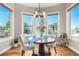 Bright breakfast nook with large windows offering serene outdoor views and a charming chandelier at 15501 Fairway Dr, Commerce City, CO 80022