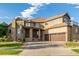 Beautiful two-story home featuring stone accents, well-manicured lawn, and a spacious driveway at 15501 Fairway Dr, Commerce City, CO 80022
