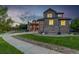 Attractive home with stone accents, a spacious lawn, and a curved driveway leading up to the property at 15501 Fairway Dr, Commerce City, CO 80022