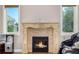 Elegant fireplace with decorative mantel, surrounded by windows and a cozy seating area at 15501 Fairway Dr, Commerce City, CO 80022