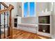 Cozy hallway area with hardwood floors, bench, and cubby shelves underneath a large window at 15501 Fairway Dr, Commerce City, CO 80022
