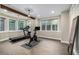 Home gym featuring fitness equipment, tile floors, ample natural light, and an accent beam at 15501 Fairway Dr, Commerce City, CO 80022