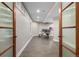 Bright home office featuring an adjustable desk, wood floors, and glass paneled doors at 15501 Fairway Dr, Commerce City, CO 80022