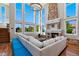 Grand living room featuring a soaring stone fireplace and bright, natural light from the wall of windows at 15501 Fairway Dr, Commerce City, CO 80022
