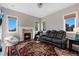 Cozy living room featuring a fireplace, a comfortable leather couch, and natural light at 15501 Fairway Dr, Commerce City, CO 80022