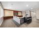 Open-concept living room with a large grey couch, decorative fireplace and entertainment center with an adjacent island at 15501 Fairway Dr, Commerce City, CO 80022