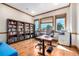 Bright office with built-in bookshelves, wood floors, and multiple windows with scenic views at 15501 Fairway Dr, Commerce City, CO 80022