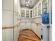 Well-organized pantry with custom shelves, white cabinets, ample storage, and hardwood floors at 15501 Fairway Dr, Commerce City, CO 80022