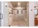 Luxurious walk-in shower featuring dual shower heads, built in bench, and glass enclosure at 15501 Fairway Dr, Commerce City, CO 80022