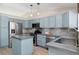 Stylish kitchen with light blue cabinets, stainless steel appliances, and an island at 5603 W 118Th Pl, Broomfield, CO 80020