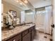 Bathroom features a granite countertop, integrated sink, and a shower-tub combo behind a white shower curtain at 9743 Chanteclair Cir, Highlands Ranch, CO 80126