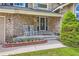 Welcoming front porch with stone accents and comfortable rocking chairs at 9743 Chanteclair Cir, Highlands Ranch, CO 80126