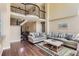 Bright living room with soaring ceilings, wrought iron railings, and comfortable neutral-toned furniture at 9743 Chanteclair Cir, Highlands Ranch, CO 80126