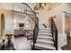 Grand staircase with wrought iron railings leading to the upper level and a view of the living room at 9743 Chanteclair Cir, Highlands Ranch, CO 80126