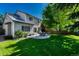 Large backyard featuring a circular patio with a table and chairs set on a sunny lawn at 21238 Snowshoe Ln, Parker, CO 80138