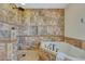 Luxurious walk-in shower and soaking tub surrounded by decorative stone tiles, creating a spa-like retreat at 21238 Snowshoe Ln, Parker, CO 80138
