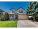 Charming two-story home featuring manicured lawn, a front porch, and attached two-car garage at 21238 Snowshoe Ln, Parker, CO 80138