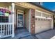 Inviting front porch with decorative railing and a glass-paneled door, adjacent to a two-car garage at 21238 Snowshoe Ln, Parker, CO 80138