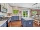 Well-lit kitchen with stainless steel appliances, blue cabinets, and an island, flowing into the dining area at 21238 Snowshoe Ln, Parker, CO 80138