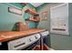 Functional laundry room has a wood countertop, shelving, and modern washer and dryer at 21238 Snowshoe Ln, Parker, CO 80138