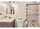 Compact bathroom featuring a tub with a tiled shower surround, a modern vanity, and decorative lighting at 7251 Larsh Dr, Denver, CO 80221