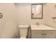 Functional bathroom featuring a toilet, a modern sink with vanity, and a framed mirror, offering a clean and updated space at 7251 Larsh Dr, Denver, CO 80221