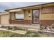 Inviting front entrance with a secure screen door and a stone bench, complemented by a well-kept yard at 7251 Larsh Dr, Denver, CO 80221