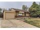 Charming brick home featuring a well-maintained front yard and attached one-car garage and a stone bench on the front porch at 7251 Larsh Dr, Denver, CO 80221
