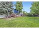 Expansive backyard featuring a well-maintained lawn, mature trees, and a deck area, offering a private outdoor space at 10621 Julian St, Westminster, CO 80031