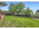 A lush backyard with healthy lawn and mature trees, perfect for outdoor activities and relaxation at 10621 Julian St, Westminster, CO 80031