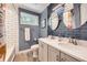 Updated bathroom featuring a double sink vanity, framed mirror and accent backsplash at 10621 Julian St, Westminster, CO 80031