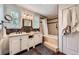Bathroom with a double sink vanity, shower and tub with horizontally tiled accent at 10621 Julian St, Westminster, CO 80031