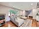 Bright living room with hardwood floors, large bay window, and comfortable sectional sofa at 10621 Julian St, Westminster, CO 80031