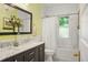 Bathroom featuring a double sink vanity, a shower and tub combo with a white shower curtain at 2155 N High St, Denver, CO 80205