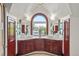 Bright bathroom featuring dual sinks, dark wood cabinets and a large arched window at 2155 N High St, Denver, CO 80205