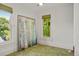 Sunlit bedroom features decorative carpet, large picture and a window with green leafy view at 2155 N High St, Denver, CO 80205