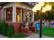 Charming covered front porch with brick details, hanging flower baskets, and decorative lion statues at 2155 N High St, Denver, CO 80205