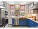 Bright kitchen features stainless steel appliances, copper sink, stylish cabinetry and hardwood floors at 2155 N High St, Denver, CO 80205