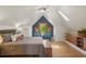 Vaulted main bedroom with a skylight, wood floors, and seating underneath a window at 2155 N High St, Denver, CO 80205