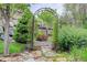 Landscaped garden with a stone pathway and decorative archway creates a peaceful backyard retreat at 5830 Jasper Pointe Cir, Castle Pines, CO 80108