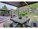Outdoor patio with built in seating, outdoor kitchen, and privacy from mature landscaping at 5830 Jasper Pointe Cir, Castle Pines, CO 80108