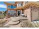 Close-up of the front entrance with a cozy seating area and steps leading to the door at 5830 Jasper Pointe Cir, Castle Pines, CO 80108