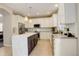 Modern kitchen featuring white cabinets, a marble countertop island, stainless steel appliances, and hardwood flooring at 5830 Jasper Pointe Cir, Castle Pines, CO 80108